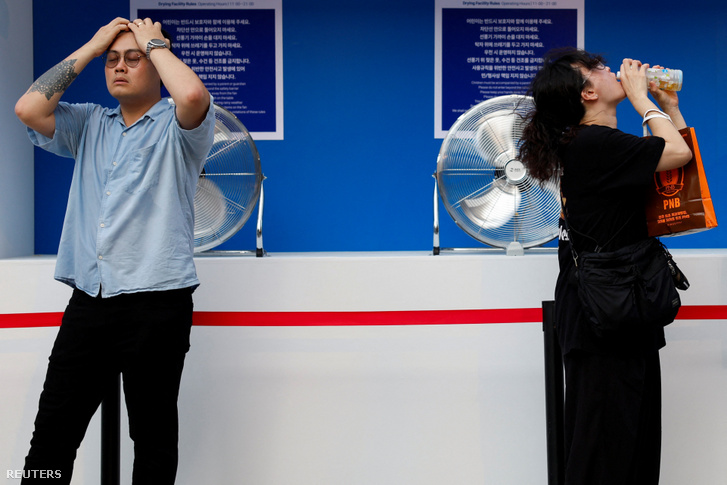 Az emberek ventilátorok előtt hűsölnek a hőhullám idején a dél-koreai Szöulban, 2026. július 31-én