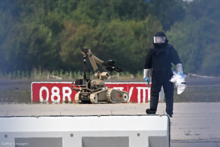 Egy helyszínelő technikus egy bombahatástalanító robot mellett dolgozik a lipcsei repülőtéren 2026. augusztus 5-én
