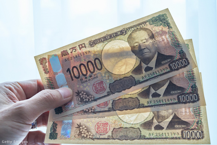 Illusztrációnkon egy férfi japán jenbankjegyeket tart a kezében