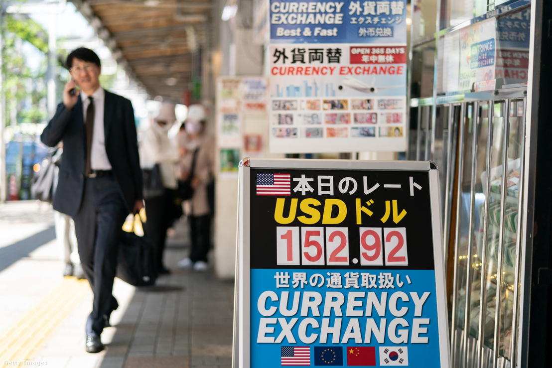 Gyalogosok haladnak el egy valutaváltó előtt, ahol egy kijelzőn a japán jen és az amerikai dollár árfolyama látható 2024. április 25-én
