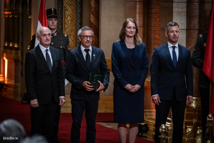 Rainer M. János (b2), miután átvette a Magyar Érdemrend nagykeresztjét Baka András köztársasági elnöktől (b), Magyar Péter miniszterelnöktől (j) és Forsthoffer Ágnestől, az Országgyűlés elnökétől (j2) az állami kitüntetések átadásán az államalapítás és Szent István király ünnepén az Országház kupolacsarnokában 2026. augusztus 20-án