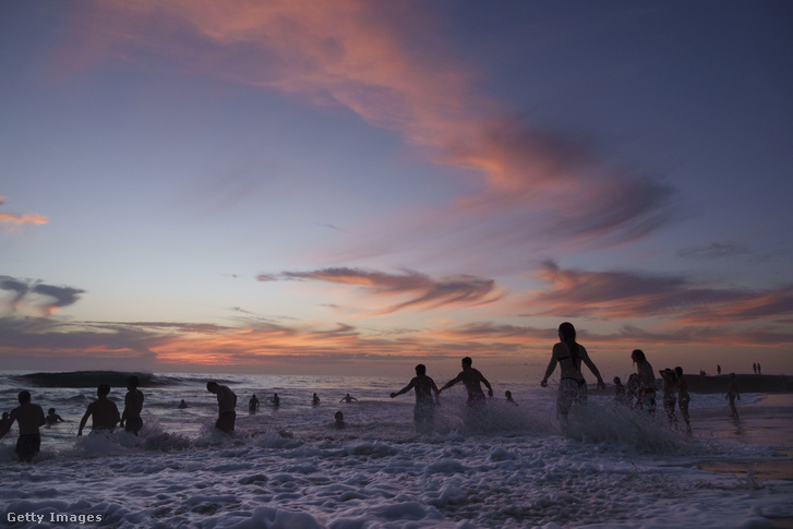 Strandolók gázolnak a Csendes-óceán vizében naplementekor a La Jolla városrészben található Windansea Beachen, a nyári hőhullám idején, 2026. augusztus 26-án, San Diegóban, Kaliforniában. A térségben az óceán hőmérséklete az év ezen időszakában a valaha mért legmagasabbak között van, miközben egy gyorsan erősödő El Niño-jelenség van kialakulóban