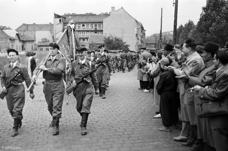 Budapest XII., Csörsz utca, a Magyar Testnevelési Főiskola sporttelepe mellett. A felvétel 1957. március 9-én, a XII. kerületi Ságvári Endre munkásőrzászlóalj megalakulásakor, a névadó és a Magyar Optikai Művek (MOM) dolgozói által adományozott csapatzászló átadási ünnepségén készült