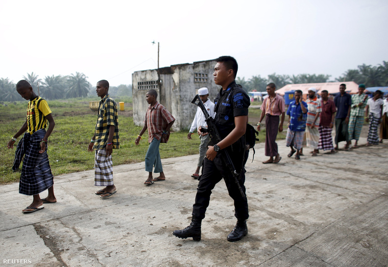 Rohingya menekülteket vezet egy indonéz rendőr egy helyi menekülttáborban.