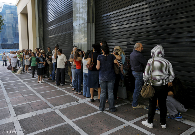 Sorbanállás a Pireus Bank bejárata előtt Athénban, 2015. július 27-én. Helyi idő szerint 10:30-kor ki kellett volna nyitnia a fiókoknak, de egyelőre zárva maradtak, egyre többen várakoznak arra, hogy készpénzt tudjanak felvenni.
