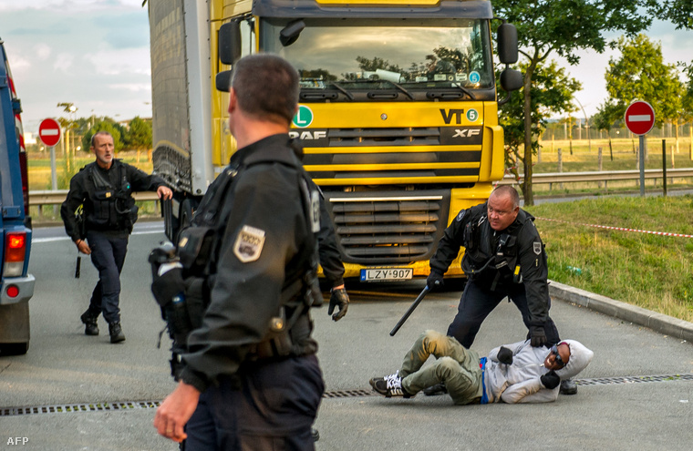 Francia rendőr próbál megállítani egy migránst a Csalagútnál, Calais közelében, 2015. július 30-án.