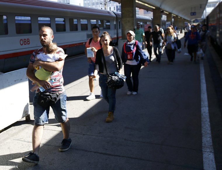 Magyarországról érkezett menekültek egy Münchenbe tartó vonat előtt a bécsi pályaudvaron.