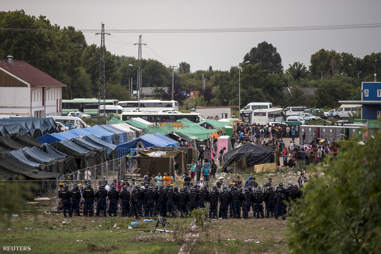 Rohamrendőrök állnak a röszkei menekülttábor kerítésénél, miután a menekültek megpróbáltak kitörni pénteken.