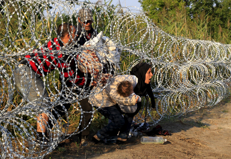 Egy család bújik át a magyar kerítésen