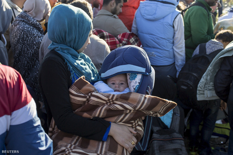 Kisgyerekes menekült család várakozik a röszkei gyűjtőpontnál, a szabad ég alatt.