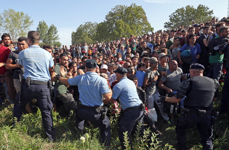 Különbuszra váró menekültek törik át a rendőrkordont a szerb-horvát közelében fekvő Tovarnik vasútállomásán, 2015. szeptember 17-én.
