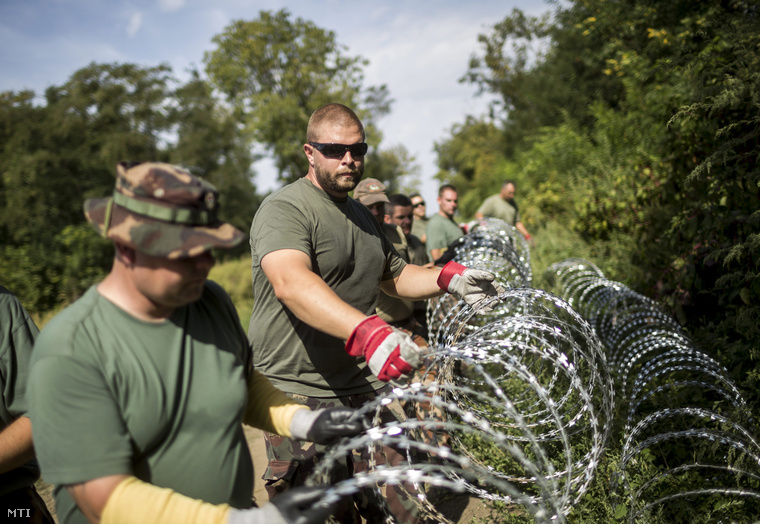 Katonák szögesdrótot helyeznek el a magyar-horvát határ magyarországi oldalán Sárok határában 2015. szeptember 18-án.