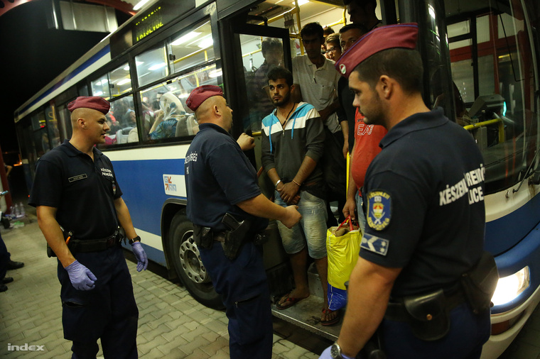 Menekültek várakoznak Beremenden péntek éjszaka, hogy a Horvátországból érkező buszokról átszállhassanak a magyar buszokra.