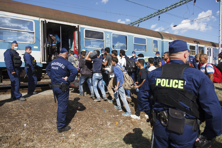 horvát-magyar zöldhatárt átlépő illegális bevándorlók rendőri felügyelettel vonatra szállnak Gyékényes vasútállomáson, Zákányban.